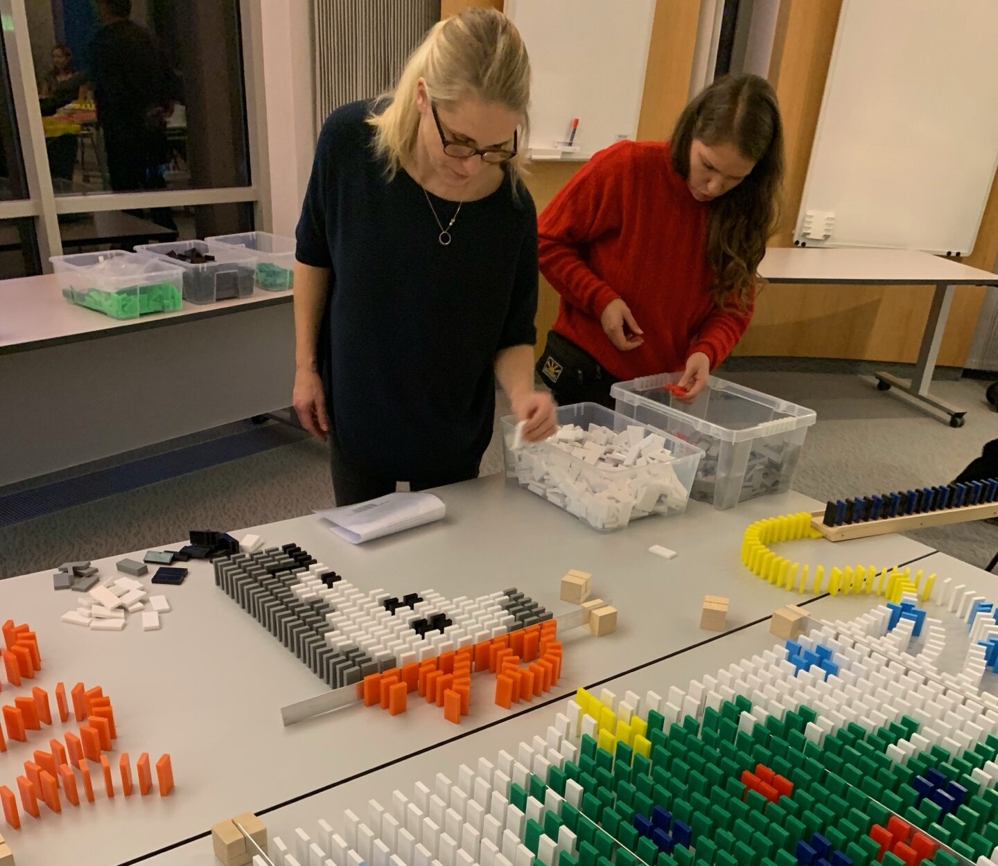 Team baut gemeinsam an einer Domino-Konstruktion mit weihnachtlichen Motiven
